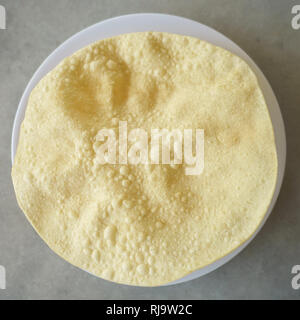 Famous Indian snack called poppadoms on table setup. Stock Photo