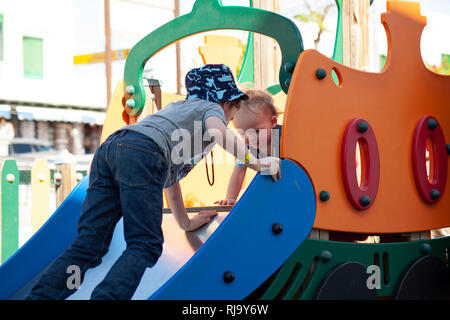 two brothers playing on slide Stock Photo