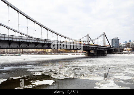 view of Krymsky (Crimean) Bridge over Moskva River with floating ice blocks in Moscow city in winter day. Krymsky Bridge is the only suspension bridge Stock Photo