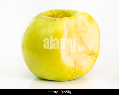 bitten yellow apple fruit on plate on white background Stock Photo