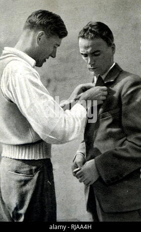 Photograph of Lauri Lehtinen (1908-1973) and Ralph Hill (1908 - 1994) exchanging pins after the 5000 meter race at the 1932 Olympic games. On the last lap, Ralph tried to overtake Lauri. Lauri blocked his way, Lehtinen crossed first 50 centimetres ahead. Although blocking was a common tactic in Europe, the American audience booed. Stock Photo