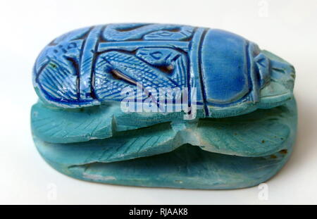 Modern replica of a blue Scarab Beetle figure, used amulets and impression seals in Ancient Egypt. They survive in large numbers and, through their inscriptions and typology, connected to the religious significance of the Egyptian god Khepri. amulets in the form of scarab beetles had become enormously popular in Ancient Egypt by the early Middle Kingdom (approx. 2000 BCE) and remained popular for the rest of the pharaonic period and beyond. Stock Photo