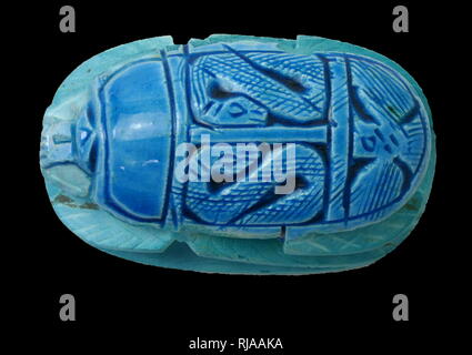 Modern replica of a blue Scarab Beetle figure, used amulets and impression seals in Ancient Egypt. They survive in large numbers and, through their inscriptions and typology, connected to the religious significance of the Egyptian god Khepri. amulets in the form of scarab beetles had become enormously popular in Ancient Egypt by the early Middle Kingdom (approx. 2000 BCE) and remained popular for the rest of the pharaonic period and beyond. Stock Photo