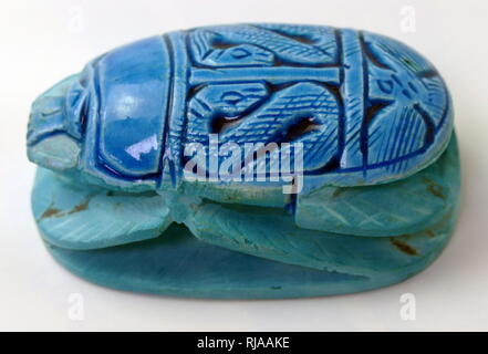 Modern replica of a blue Scarab Beetle figure, used amulets and impression seals in Ancient Egypt. They survive in large numbers and, through their inscriptions and typology, connected to the religious significance of the Egyptian god Khepri. amulets in the form of scarab beetles had become enormously popular in Ancient Egypt by the early Middle Kingdom (approx. 2000 BCE) and remained popular for the rest of the pharaonic period and beyond. Stock Photo