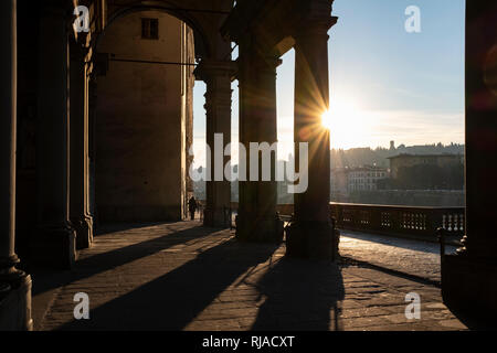 Early morning sunlight casting long shadows through the columns of the entrance to the Uffizi Gallery on the banks of the River Arno Florence Italy Stock Photo