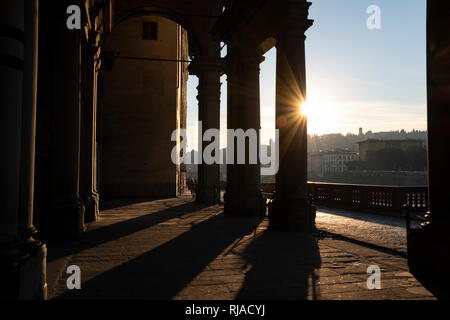 Early morning sunlight casting long shadows through the columns of the entrance to the Uffizi Gallery on the banks of the River Arno Florence Italy Stock Photo