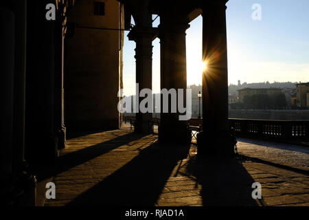 Early morning sunlight casting long shadows through the columns of the entrance to the Uffizi Gallery on the banks of the River Arno Florence Italy Stock Photo