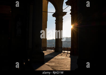 Early morning sunlight casting long shadows through the columns of the entrance to the Uffizi Gallery on the banks of the River Arno Florence Italy Stock Photo