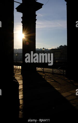 Early morning sunlight casting long shadows through the columns of the entrance to the Uffizi Gallery on the banks of the River Arno Florence Italy Stock Photo