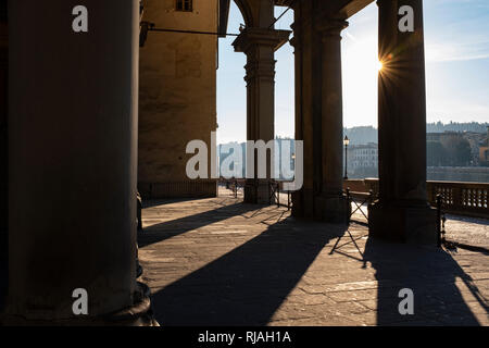 Early morning sunlight casting long shadows through the columns of the entrance to the Uffizi Gallery on the banks of the River Arno Florence Italy Stock Photo