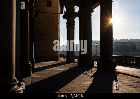 Early morning sunlight casting long shadows through the columns of the entrance to the Uffizi Gallery on the banks of the River Arno Florence Italy Stock Photo