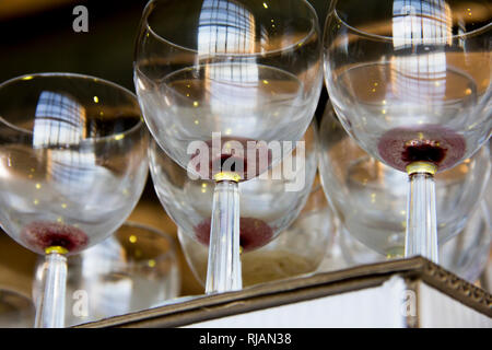 Wine glasses and bottles on the table after the exhibition opening and presentation. Stock Photo
