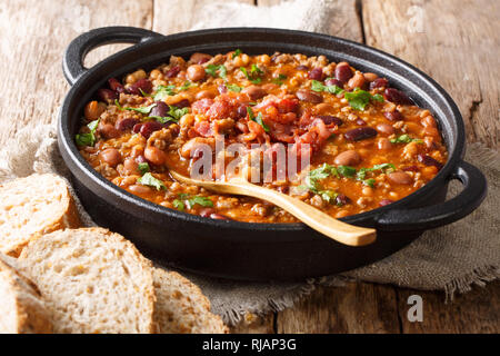 Barbecue cowboy beans with ground beef, bacon in a spicy sauce closeup in a bowl on the table. horizontal Stock Photo