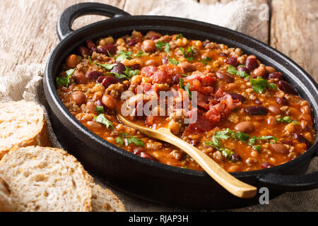 Crock pot beans with ground beef, bacon in a spicy sauce closeup in a bowl on the table. horizontal Stock Photo