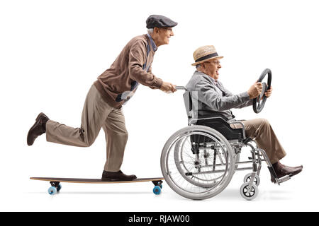 Full length profile shot of an elderly man riding a longboard and pushing a man holding a steering wheel and sitting in a wheelchair isolated on white Stock Photo
