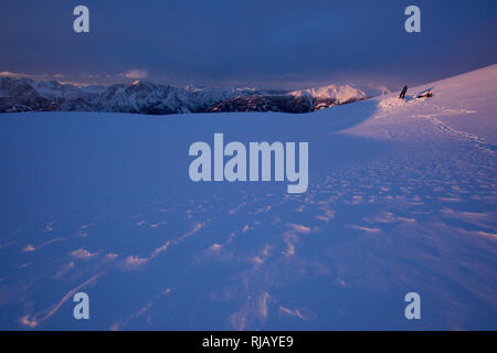 Bergsteiger vor Schneehöhle am Goisele bei Sonnenaufgang, Schobergruppe, Osttirol, Österreich. Stock Photo