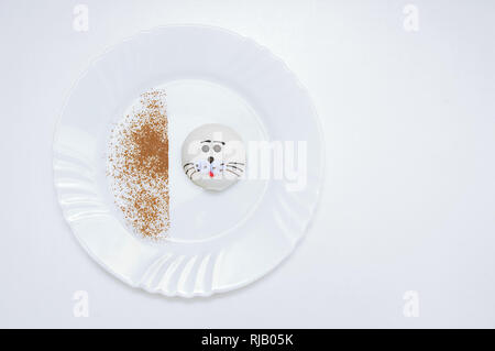 Souffle cupcake in the shape of a fur seal on a white plate. White background. Stock Photo