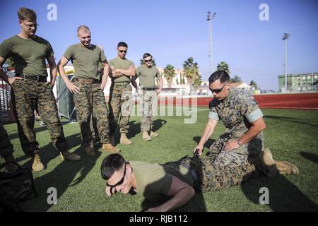 Staff Sgt. Joseph Mendoza, a non-lethal weapons instructor with Special Purpose Marine Air-Ground Task Force Crisis Response-Africa, stuns a Marine with the X26 Taser during non-lethal training at Naval Air Station Sigonella, Italy, Nov. 1, 2016. Marines completed a weeklong non-lethal course, which covered Taser training, OC exposure and riot control team tactics. Stock Photo