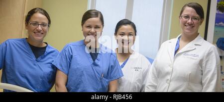 From left, Lt. Jessica Dalrymple, Lt. Suzanne Papadakos, Lt. Christine Johnson, staff nurses with U.S. Naval Hospital Guam (USNH Guam), and Lt. Cmdr. Rozalyn Love, USNH Guam staff physician, pose following postpartum hemorrhage (PPH) training at the USNH Guam Mother Baby Unit.  The training, which was rolled out two months early at USNH Guam, is part of a Military Health System review of postpartum hemorrhages. Staff physicians, nurses, and Corpsmen involved in labor and delivery at USNH Guam will be participating in PPH drills and training every three months. Stock Photo