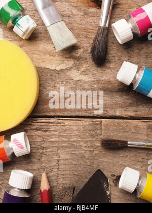 Artistic painter utensils on a wooden table with space for text or image in the center Stock Photo