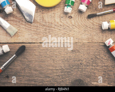 Assortment of different painter utensils on a rustic wooden table with space for your text in the center Stock Photo