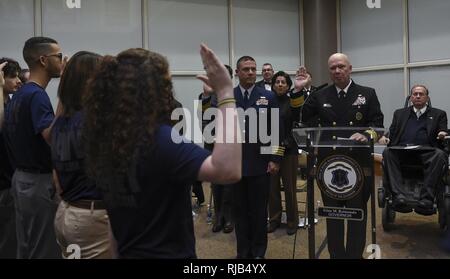 PROVIDENCE, R.I. (Nov. 5, 2016) Rear Adm. Jeffrey A. Harley, president, U.S. Naval War College, administers the federal oath of enlistment to people entering the military during a ceremony honoring U.S. military veterans at the Rhode Island Department of Education building. “To the young men and women who have entered the military today, you are now among the list of proud veterans who have served before you and who continue to serve today,” said Harley. The ceremony was followed by a torch procession by veterans who walked from the Department of Education building to Waterplace Park for the “ Stock Photo