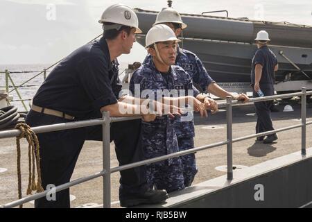PACIFIC OCEAN (Nov. 7, 2016) Ensign Timothy Ferguson, left, discusses small boat operations aboard amphibious dock landing ship USS Comstock (LSD 45) with Petty Officer 2nd Class Kazuhiko Iwanatsu, center, and Lt. j.g. Shogo Kudo during Keen Sword 17. Keen Sword 17 is a joint and bilateral field training exercise (FTX) between U.S. and Japanese forces meant to increase readiness and interoperability within the framework of the U.S.-Japan alliance.