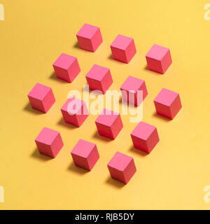 Pink wooden blocks on a yellow background. Modern conceptual art. Stock Photo