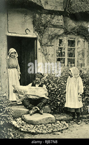 Man reading newspaper outside his cottage, Shropshire Stock Photo