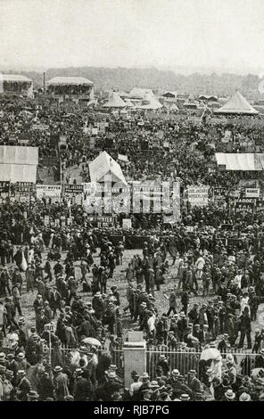 Aerial view of Derby Day at Epsom racecourse, Epsom Downs, Surrey, England, with people milling around, and bookmakers' signs and stands.