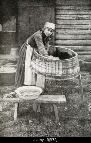 Young housewife at work, doing the laundry in a three-legged washtub, Republic of Estonia. Stock Photo