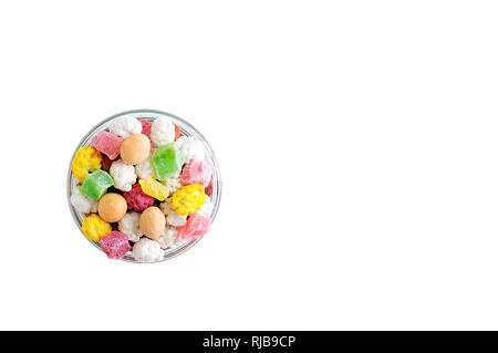 Dried fruit slices, nuts and candies in the glaze in a glass bowl. White isolate Stock Photo