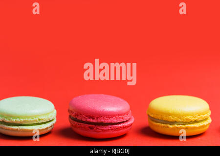 Close up of French macaroons on red background with copy space Stock Photo
