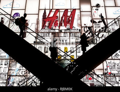 silhouette of people on internal escalators at  H&M Regents street London, Stock Photo