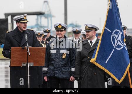 ZEEBRUGES, Belgium (Jan. 15, 2018)  Rear Admiral Jens Nemeyer (L), Allied Maritime Command representative, opens a ceremony marking the change of command of Standing NATO Mine Counter Measure Group One (SNMCMG1) under a heavy rain at Zeebruges Marine Base, in Belgium. SNMCMG1 is one of four standing NATO maritime groups continuously ready to support NATO tasking in defense of the Alliance. Stock Photo