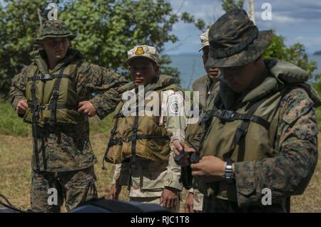 U.S. Marines and Royal Cambodian Navy Sailors don life jackets before an amphibious raid on Ream Naval Base, Sihanoukville, Cambodia, Nov. 2, 2016. U.S. Marines instructed the Cambodian Sailors on Combat Rubber Reconnaissance Craft (CRRC) operation and amphibious raids during Cooperation Afloat Readiness and Training (CARAT) 16. CARAT 2016 is a nine-country, bilateral exercise series between the United States and Bangladesh, Brunei, Cambodia, Indonesia, Malaysia, Singapore, the Philippines, Thailand, and Timor-Leste. This phase of CARAT focuses on partnerships between the forces of the US and  Stock Photo