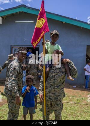 U.S. Marines Sgt. Wesley Davison, radio operator with Headquarters Platoon, and Cpl. Matthew Miller, combat engineer with Combat Engineer Platoon, Task Force Koa Moana 16-4, meet children at the kindergarten they renovated in Port Vila, Vanuatu, Nov. 1, 2016. During the closing ceremony, task force leadership and key leaders in the Vanuatu Police Force thank each other for their hard work, training and participation throughout their time together. Stock Photo