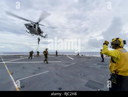 PACIFIC OCEAN (Nov. 2, 2016) Petty Officer 2nd Class Ramiro Alvarez, from Lawrenceville, Ga., directs a UH-1 Huey helicopter as Marines attached to the 11th Marine Expeditionary Unit (MEU) repel during a fast-rope training aboard the amphibious transport dock ship USS Somerset (LPD 25). Somerset is on its maiden deployment as part of the Makin Island Amphibious Ready Group, and is operating in the U.S. 7th Fleet area of operations with the embarked 11th MEU in support of security and stability in the Indo-Asia-Pacific region.