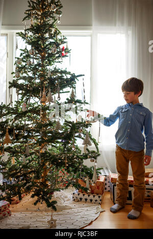 Boy standing in front of a Christmas tree Stock Photo