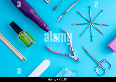 A set of cosmetic tools for professional manicure, nail care and to create beautiful designs on a blue background. Top view Stock Photo