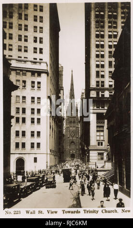 Wall Street - New York City - The heart of Manhattan's business district, with Trinity Church dominating the narrow street. Stock Photo