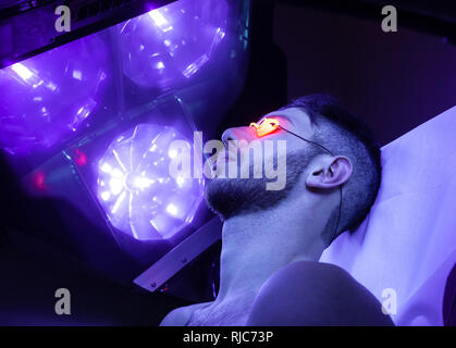 Young Thin Man At Solarium In Beauty Salon. Stock Photo
