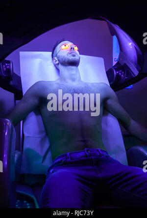 Young Thin Man At Solarium In Beauty Salon. Stock Photo