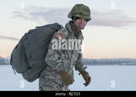 Army Pvt. Conner Langley, a native of Baton Rouge, La., assigned to the 6th Brigade Engineer Battalion, 4th Infantry Brigade Combat Team (Airborne), 25th Infantry Division, U.S. Army Alaska, smiles after completing his first airborne training jump at Malemute drop zone, Joint Base Elmendorf-Richardson, Alaska, Jan. 9, 2018. The Soldiers of 4/25 belong to the only American airborne brigade in the Pacific and are trained to execute airborne maneuvers in extreme cold weather/high altitude environments in support of combat, training and disaster relief operations. Stock Photo