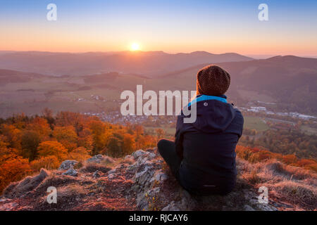 Young woman enjoying the view from high lookout of the Bruchhauser Steine (Feldstein), Bruchhausen, into the beautiful Sauerland in fall, Germany, Stock Photo