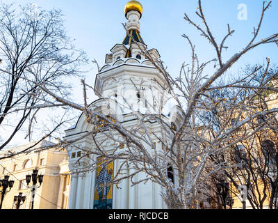 Xmas decorated tree near Chapel of St Nicholas the Wonderworker of Mozhaisk on Borovitskaya Square in Moscow city in winter Stock Photo