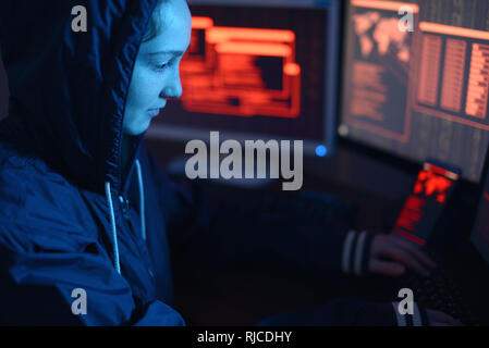 Hacker typing program code while committing a cybercrime hacking a ...