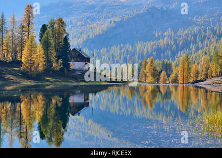 Rifugio Croda da Lago reflected in Lago de Federa, Dolomites, Belluno, Veneto, Italy.  Autumn Stock Photo