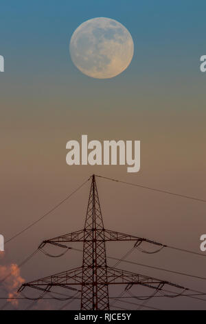 Full moon over a high voltage pylon, Duisburg, Stock Photo