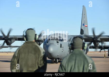 U.S. Air Force Airman 1st Class John Rojas, left, and Senior Airman Logan Ferguson, both 317th Aircraft Maintenance Squadron crew chiefs prepares to taxi a C-130J Super Hercules at Dyess Air Force Base, Texas, Jan. 8, 2018. Members of the 317th AW deployed to Djibouti, Africa and Ramstein Air Base, Germany to provide intra-theater airlift capabilities, while supporting the East Africa Response Force in addition to the personnel recovery mission for the Combine Joint Task Force-Horn of Africa. Stock Photo